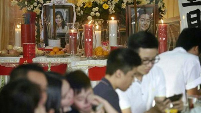 Gia đình đặt di ảnh của Thejakusuma và con gái trong buổi lễ hôm qua. Ảnh: Straits Times.