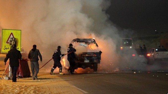Lực lượng an ninh đang dập tắt một đám cháy tại hiện trường vụ xô xát. Ảnh: AFP.