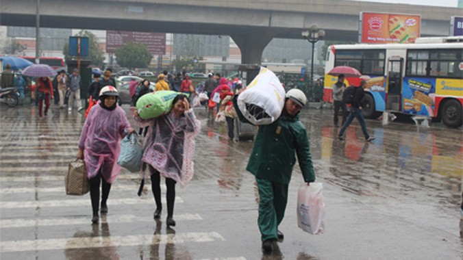 Người dân đội mưa đổ về bến xe ngày một đông.