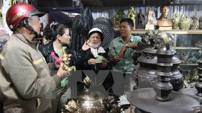 Du khách dự hội chọn mua những món đồ cổ, giả cổ cầu may đầu Xuân tại Chợ Viềng 2014. Ảnh: Thanh Tùng/TTXVN.