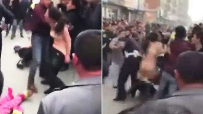 Cảnh hỗn loạn giữa đường phố khi người phụ nữ cởi trần lao vào đánh nhau với cảnh sát trước sự chứng kiến của những người qua lại. Ảnh: CEN.