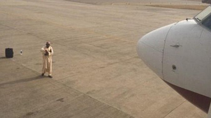 Vị khách này tức giận vì chuyến bay tới Sokoto bị hủy, nên đã đứng chặn ngay trước mũi máy bay. Ảnh: Cedar Chiwuba.