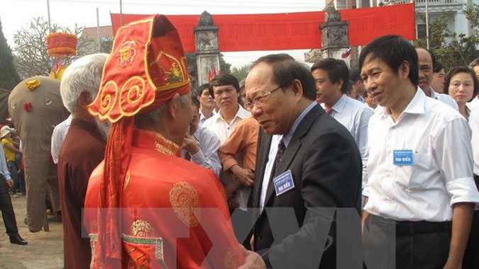 Bộ trưởng Hoàng Tuấn Anh hỏi thăm các lão niên về việc tổ chức lễ hội rước voi ở xã Đào Xá. Ảnh: Tạ Toàn/TTXVN.