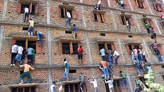 Phụ huynh và người thân thí sinh bất chấp nguy hiểm để leo lên tầng cao ném tài liệu cho con em mình tại một điểm thi ở quận Vaishali, bang Bihar. Ảnh: Hindustan Times.