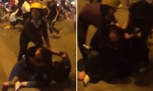 Một người lớn tuổi (đội mũ vàng) chật vật can ngăn hai cô gái đánh nhau trong nhóm hỗn chiến trên phố Bà Triệu đêm qua. 