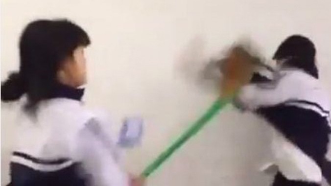 Hình ảnh nữ sinh tấn công nam sinh cùng lớp bằng chổi quét nhà. Ảnh cắt từ video.