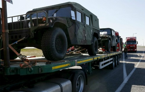 Xe tải chở xe quân sự Mỹ ở Ukraine. Ảnh: Reuters.