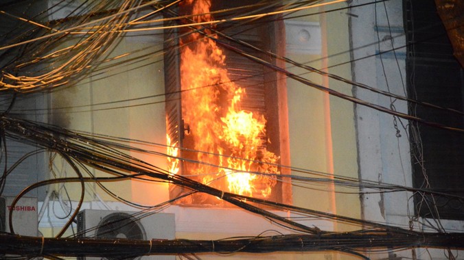 Ngọn lửa cháy táp qua cửa lầu một của căn nhà.