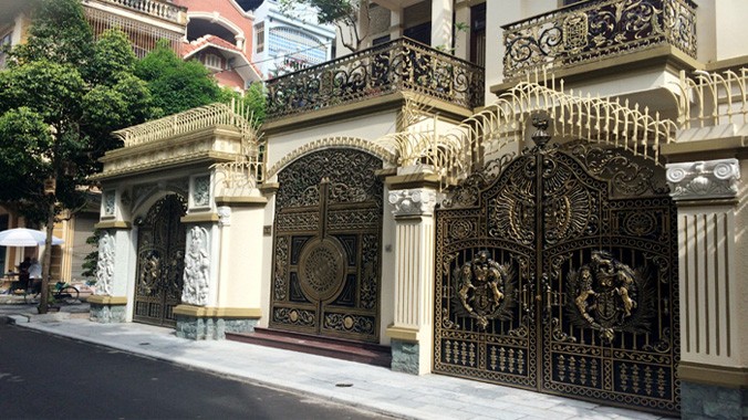 Những chiếc cổng nhôm đúc mạ đồng của ba ngôi biệt thự giống hệt nhau.