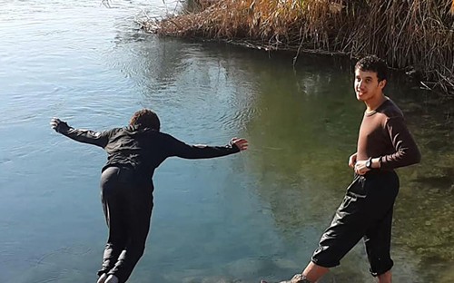 Một đôi vợ chồng là thành viên IS đang vui đùa bên sông Euphrates. Ảnh: AP.