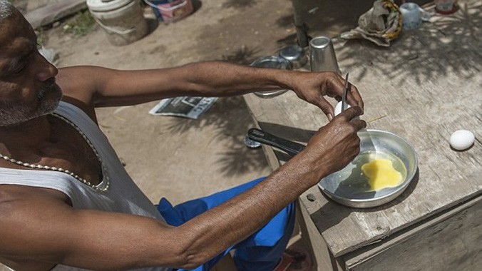 Ajay Yadav, một người dân Ấn Độ, rán trứng bằng sức nóng của mặt trời. Tính đến ngày 30/5, thời tiết cực đoan ở quốc gia Nam Á đã khiến hơn 2.000 người chết. Người dân ở nhiều khu vực đang vật lộn với tình trạng thiếu nước, thiếu điện. Ảnh: Daily Mail