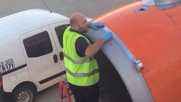Nhân viên sân bay dùng băng dính để dán lên mép nối trên vỏ tuabin trước khi máy bay cất cánh. Nguồn: Daily Mail.