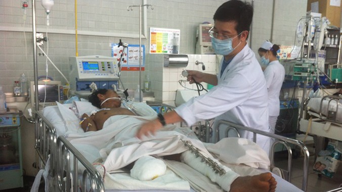 Bác sĩ Huy đang thăm khám cho anh Tám tại khoa hồi sức cấp cứu Bệnh viện Chợ Rẫy. Ảnh: Quốc Ngọc.