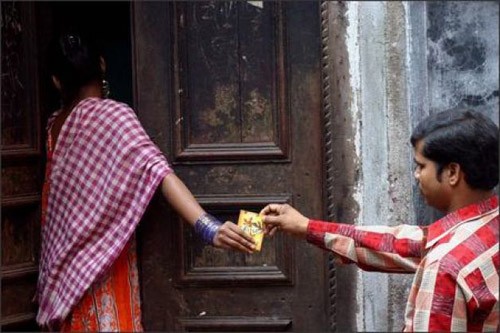 Một gái mại dâm nhận bao cao su miễn phí từ tình nguyện viên tại phố đèn đỏ ở thành phố Calcutta, bang Tây Bengal. Ảnh: AP.