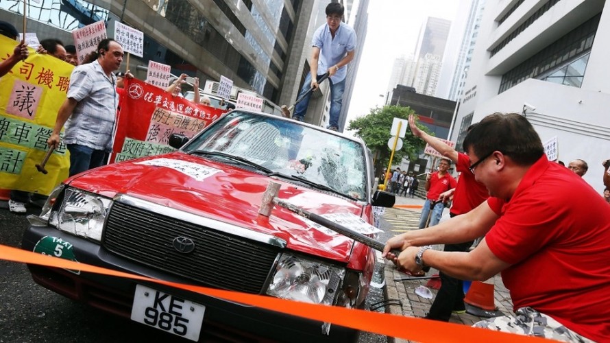 Nhóm tài xế taxi Hồng Kông tức giận đập phá taxi phản đối Uber (Ảnh: Bưu điện Hoa Nam buổi sáng).