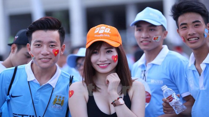 Một người đẹp chụp ảnh cùng các fan Manchester City. Ảnh: Minh Chiến/Vietnam+.