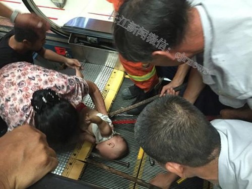 Bé trai một tuổi ở Trung Quốc bị kẹt tay trong thang cuốn hôm 27/7. Ảnh: Shanghaiist.