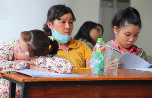 Nhiều phụ huynh mệt mỏi nằm gục ở Đại học Sư phạm TP HCM vì phải chờ nhiều giờ đồng hồ mới rút được hồ sơ. Ảnh: Nguyễn Loan.