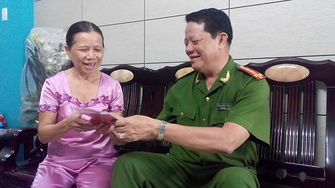 Bà Phạm Thị Thu Vân, là một trong mười người dân được cấp lại số chứng minh mới trong ngày 28/8, vui mừng khi cầm chứng minh nhân dân mới. Ảnh Việt Văn.