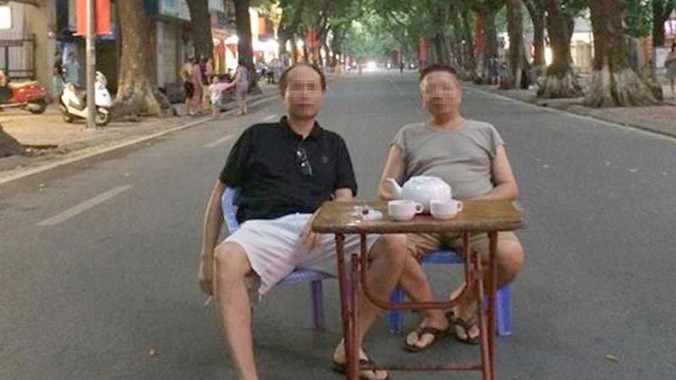 Bức ảnh hài hước 2 người đàn ông ngồi uống trà giữa đường Phan Đình Phùng. Ảnh: Phạm An.