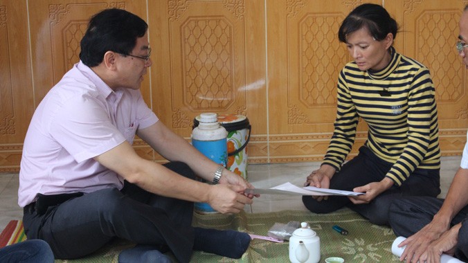 Ông Lê Xuân Sơn - Tổng Biên tập báo Tiền Phong trao tiền hỗ trợ cho vợ nạn nhân Đặng Văn Toanh.