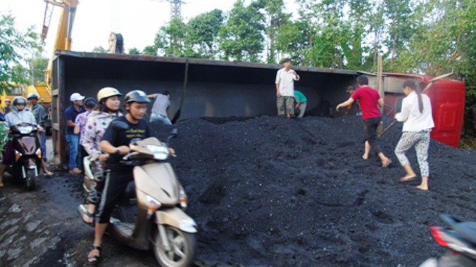 Xe tải lật ngửa khiến hàng chục tấn than đổ ra đường.