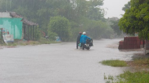 Nước ngập nhiều khu vực, người dân phải dắt bộ vì tắt máy. Ảnh: Nguyễn Trang.