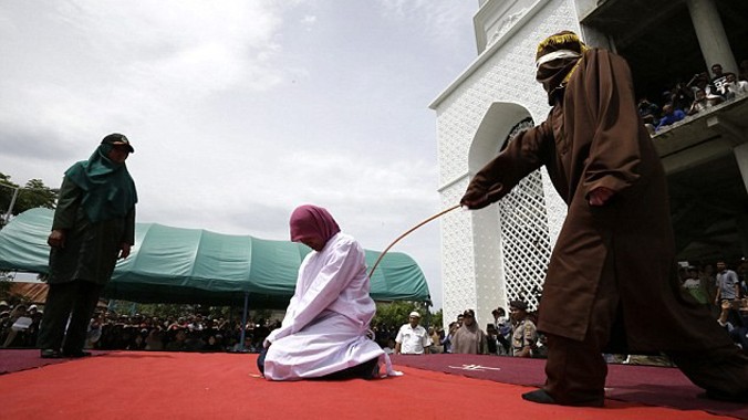 Một phụ nữ quỳ chịu roi ở tỉnh Banda Aceh, Indonesia. Ảnh: EPA.