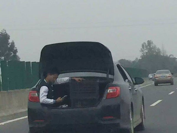 Nam thanh niên vô tư ngồi trong cốp xe khi đi trên cao tốc.