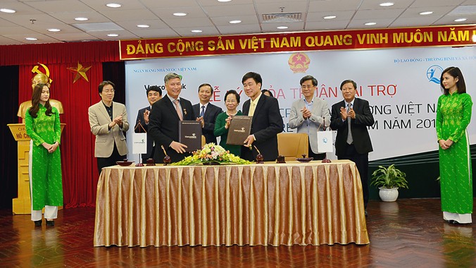 Đại diện Vietcombank, ông Nguyễn Danh Lương - Ủy viên HĐQT, Phó Tổng giám đốc (hàng đầu bên trái) và đại diện Quỹ BTTE, ông Hoàng Văn Tiến - Giám đốc ký thỏa thuận tài trợ và nhận tài trợ.