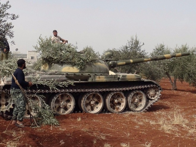 Nhóm chiến binh nổi dậy dùng cành cây để ngụy trang xe tăng ở phía bắc thành phố Aleppo. Ảnh: Reuters.