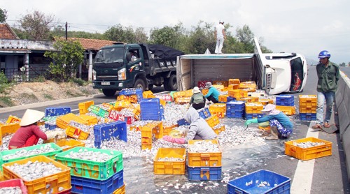 Hàng tấn cá đổ tràn xuống đường khi xe tải lật nhào. Ảnh: Xuân Ngọc/VnExpress