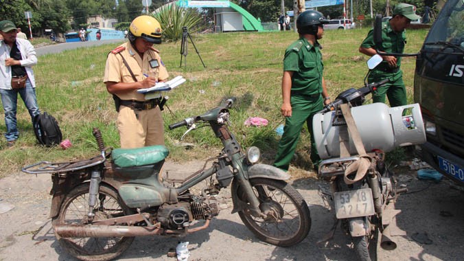 Cảnh sát giao thông lập biên bản xử lý một trường hợp xe máy “cà tàng”. Ảnh Việt Văn.