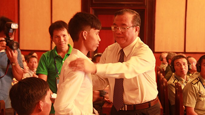 Ông Huỳnh Văn Tí, Thứ trưởng Bộ LĐ-TB&XH, trao quà, động viên gia đình em Nguyễn Đức Ánh, một trong những nạn nhân bom mìn sót lại sau chiến tranh.