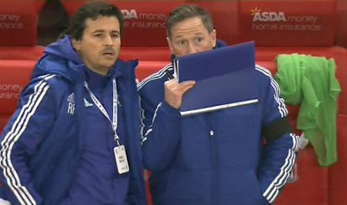 Trợ lý Holland (phải) nói chuyện qua bộ đàm giữa trận. Ảnh: Sky Sports.