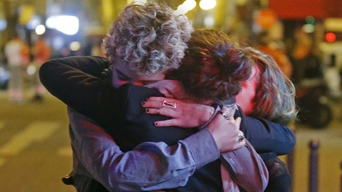 Người sống sót ôm nhau sau vụ tấn công liên hoàn đẫm máu ở Paris. Ảnh: Reuters.