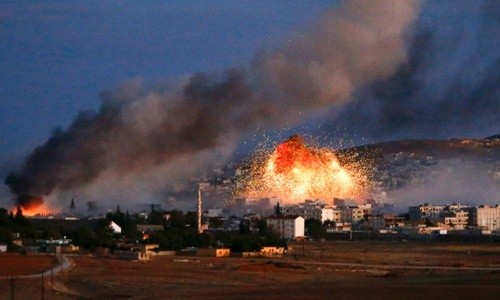 Khói lửa bốc lên từ thị trấn Kobani, Syria, sau khi trúng đòn không kích của Mỹ. Ảnh: CBC.