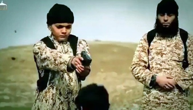 Chiến binh IS nhí xuất hiện trong video tuyên truyền của tổ chức giơ súng chuẩn bị bắn một con tin. Ảnh: IBTimes.