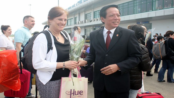 Ông Phan Tiến Dũng, Giám đốc Sở VH-TT&DL TT-Huế, nồng nhiệt chào đón, tặng hoa, quà chúc mừng những du khách đầu tiên đến Huế trong năm mới 2016 bằng đường hàng không.