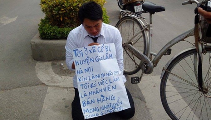 Nguyễn Việt Hải quỳ trước cổng Đài truyền hình với tấm biểu ngữ xin việc.