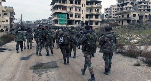 Binh sĩ chính phủ Syria đi bộ trong thị trấn Salma, tỉnh Latakia.