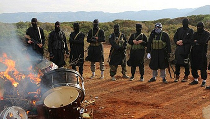 Chiến binh IS ở Libya đốt một nhạc cụ trong video tuyên truyền. Ảnh: clarionproject.org.
