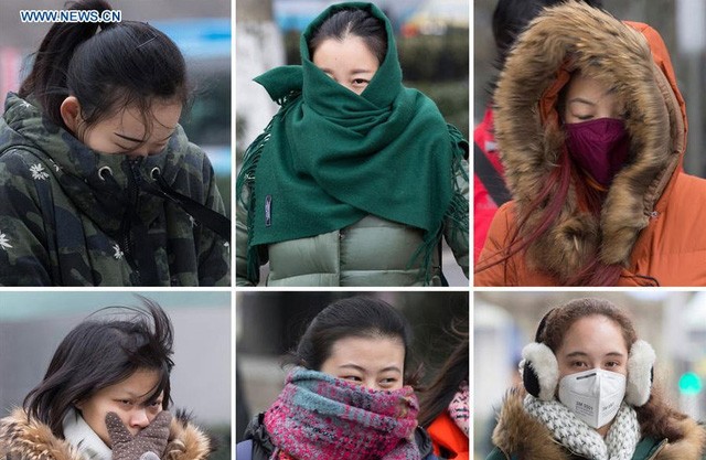 Người dân mặc áo ấm ra đường trong gió lạnh.