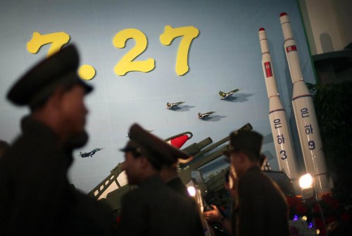 Lính Triều Tiên đứng bên cạnh mô hình tên lửa đẩy Unha 3 tháng 7/2013. Ảnh: AP.