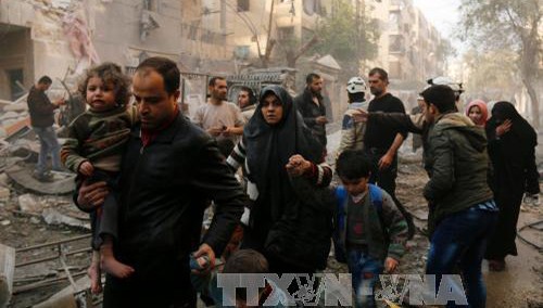 Người dân Syria sơ tán sau các cuộc không kích của quân đội chính phủ vào các mục tiêu của phiến quân ở thành phố Aleppo ngày 13/1. Ảnh: AFP/TTXVN.