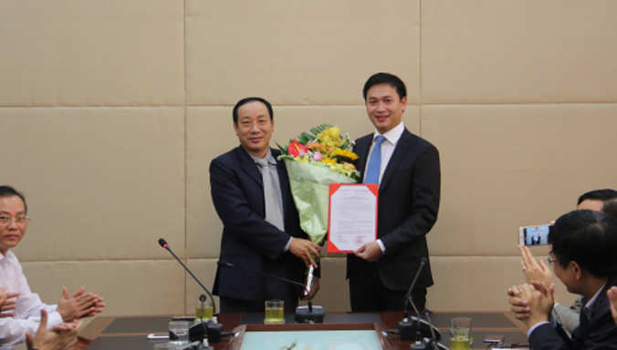 Thứ trưởng Nguyễn Hồng Trường trao Quyết định và tặng hoa cho ông Nguyễn Xuân Ảnh. 
