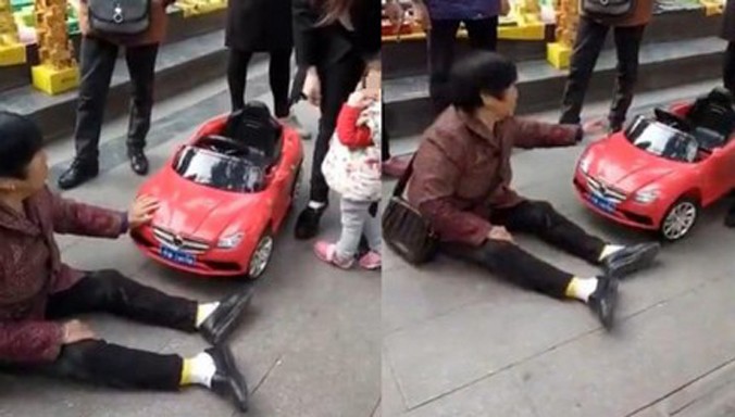 Người phụ nữ đang ngồi trước chiếc xe đồ chơi như thể lo ngại chiếc xe sẽ bị “lái” đi khỏi hiện trường.