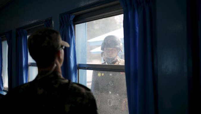 Một lính Triều Tiên (phải) đang nhìn lính Hàn Quốc qua cửa sổ phòng họp tại làng đình chiến Panmunjom thuộc khu phi quân sự giữa hai miền. Ảnh: Kim Hong-Ji.