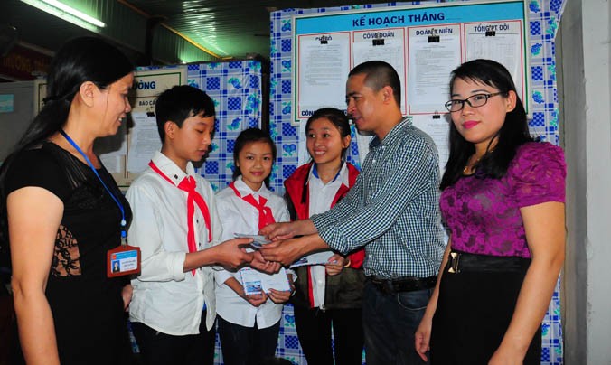 Nhà báo Quang Long, đại diện báo Tiền phong tặng quà của báo và Qũi Hỗ trợ tài năng trẻ VN cho các em học sinh có tác phẩm xuất sắc. Ảnh: Sỹ Lực.
