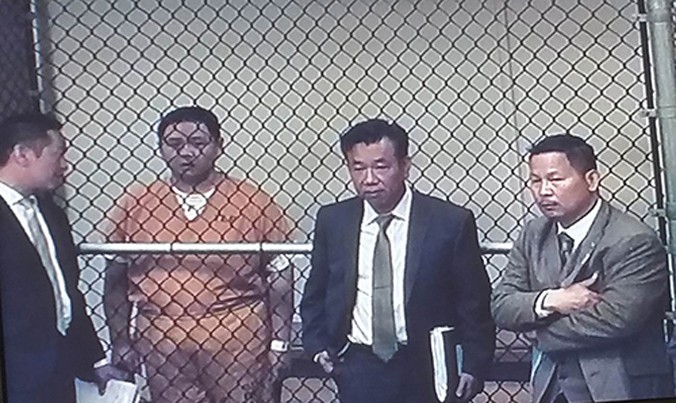 Diễn viên Minh Béo (áo cam) tại buổi luận tội. Từ trái qua: thông dịch viên của Minh Béo, luật sư Đỗ Phủ và luật sư Anh Tuấn do gia đình diễn viên thuê. Ảnh: Ngọc Lan chụp qua màn hình.